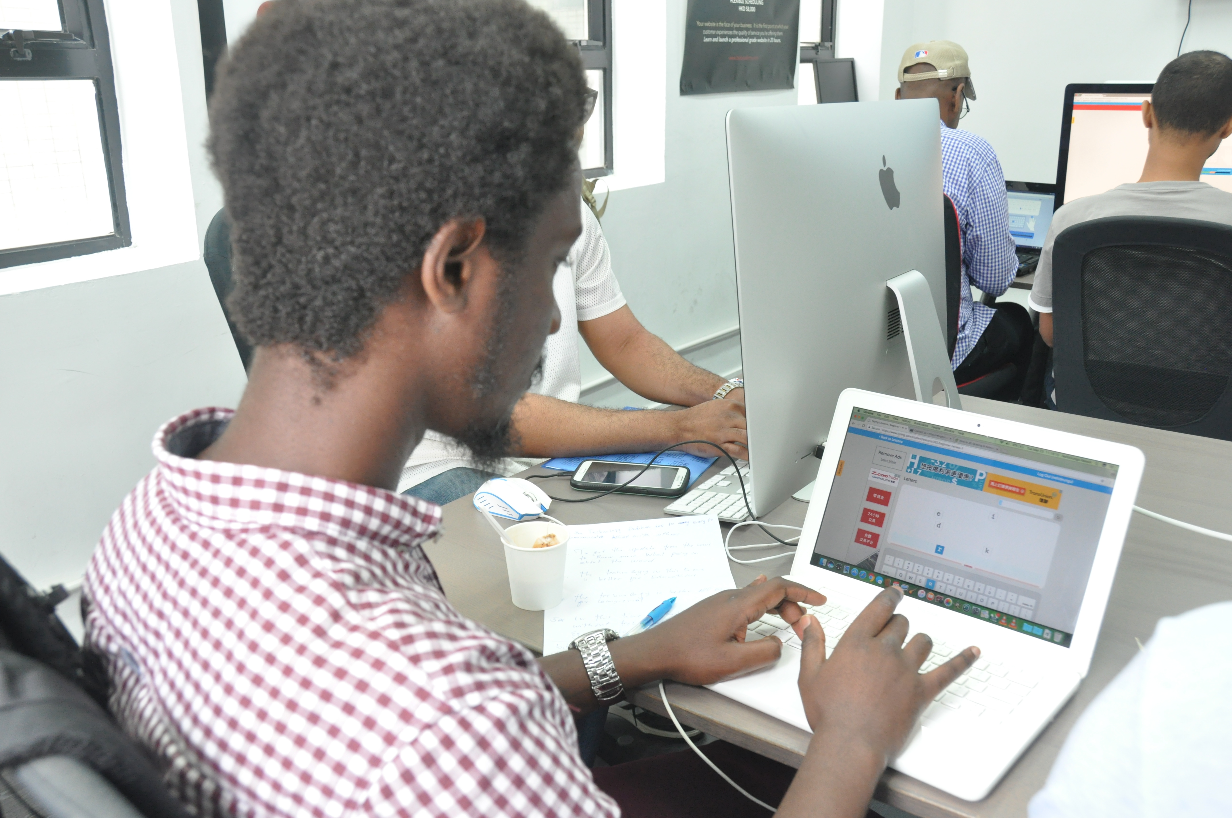 RefuGeek students working at computers during a workshop session